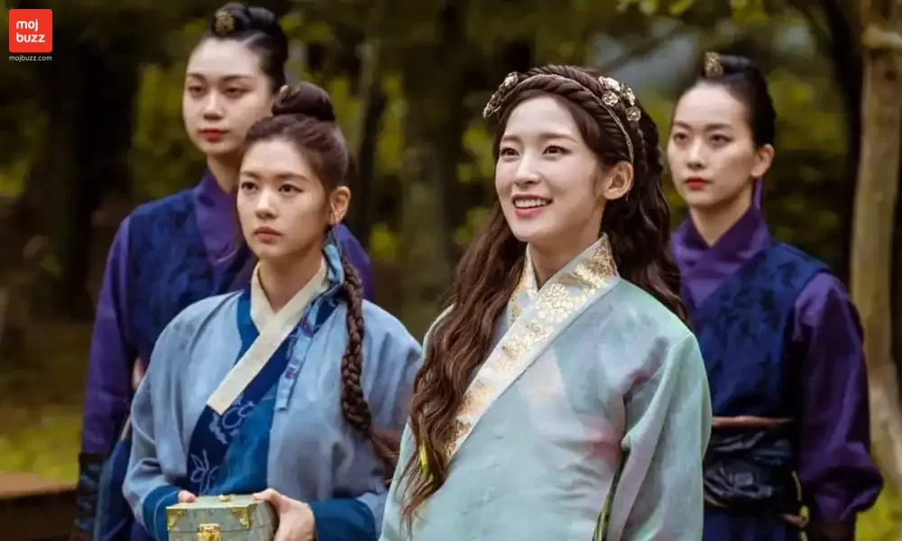 A women smiling and 3 women standing behind her
