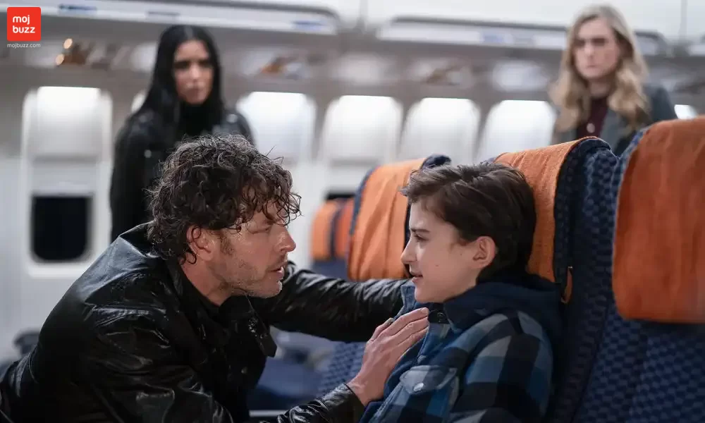 A man talking to a boy in a plane and 2 women standing behind and watching them