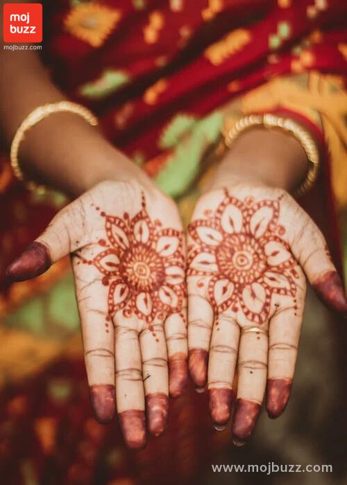 A Indian women showing her both hands with mehndi pattern on it