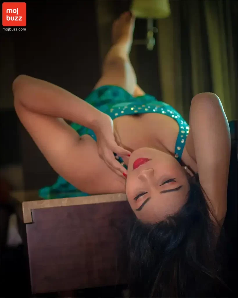 A woman (Inaya Sultana) lying down on desk for sexy pose