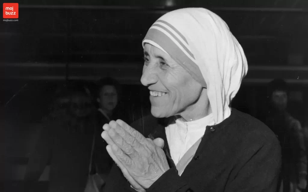 Mother Teresa smiling with both hands together